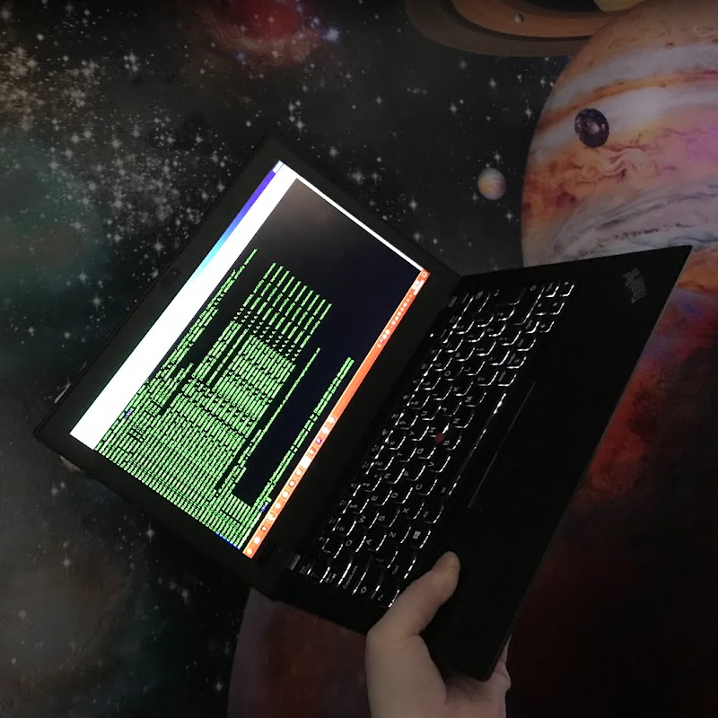 An image of a thinkpad x280, held in front of a wall decorated to look like outer space.